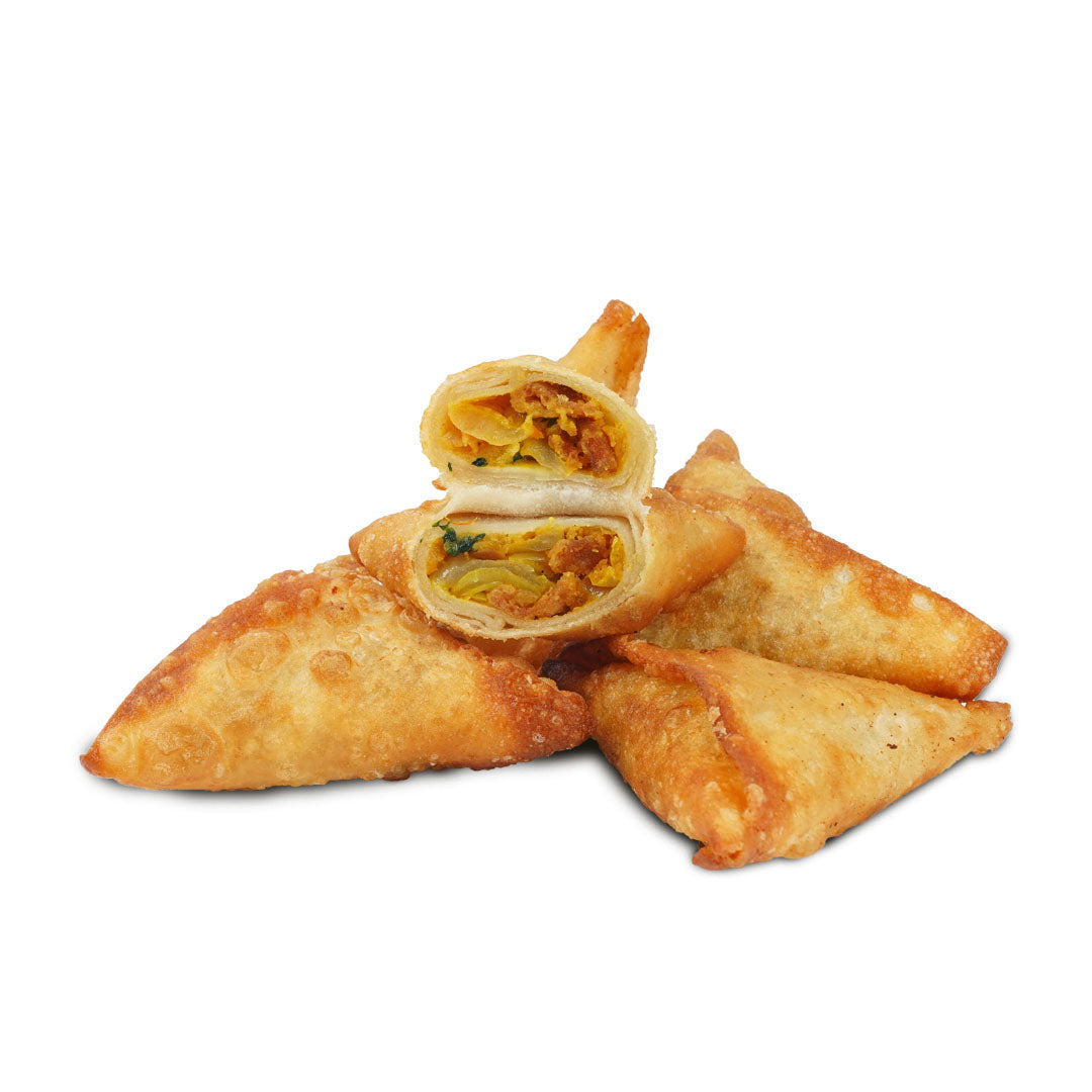 A stack of  golden-brown  frozen samosas, some cut open to show the spicy